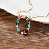 Collar con iniciales y piedras preciosas doradas de 18 quilates