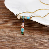 Collar con iniciales y piedras preciosas doradas de 18 quilates