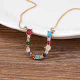 Collar con iniciales y piedras preciosas doradas de 18 quilates