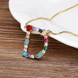 Collar con iniciales y piedras preciosas doradas de 18 quilates